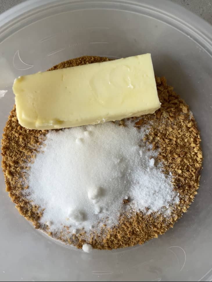 Sugar, breadcrumbs, and butter are ready to mix in a bowl.