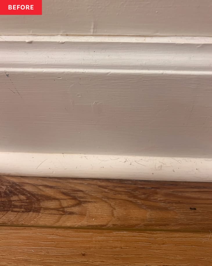 Dust and pet hair on baseboard before being cleaned with baseboard cleaning hack.