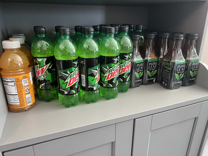 bottles of juice, mountain dew, and tea on gray hutch