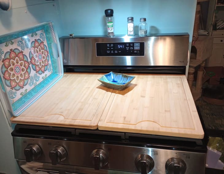 Stovetop with 2 Aldi cutting boards working as extra counter space