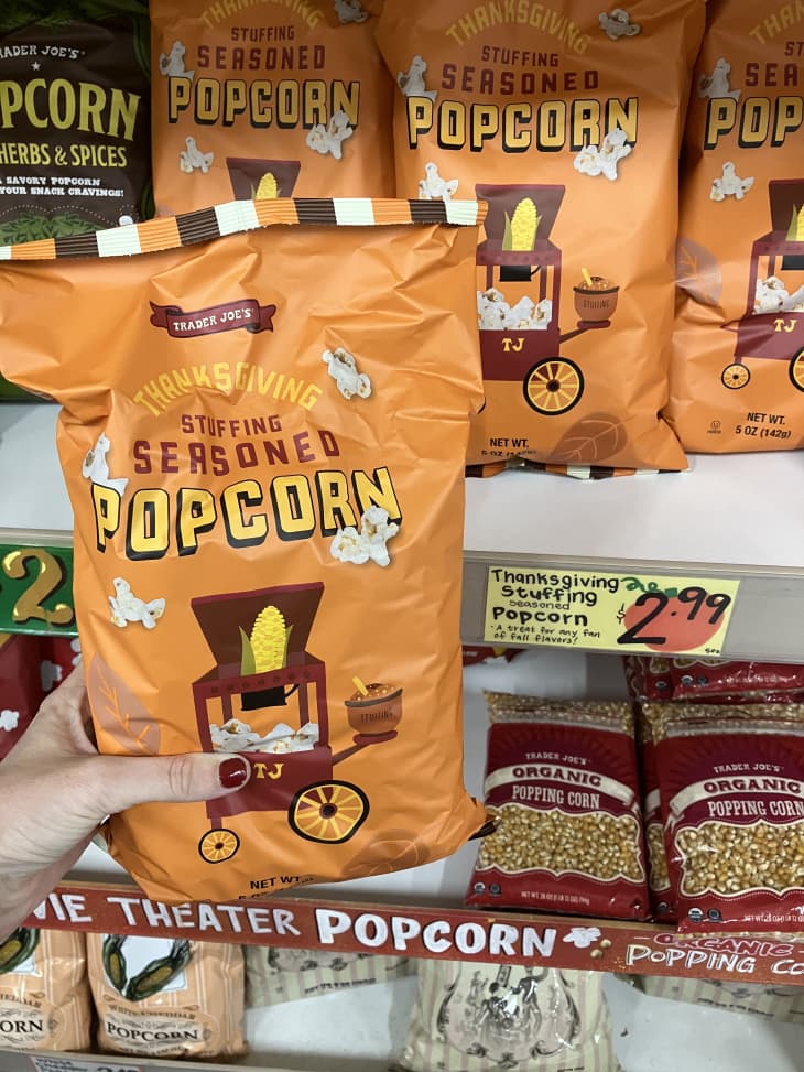 stuffing seasoned popcorn in orange bag on shelf