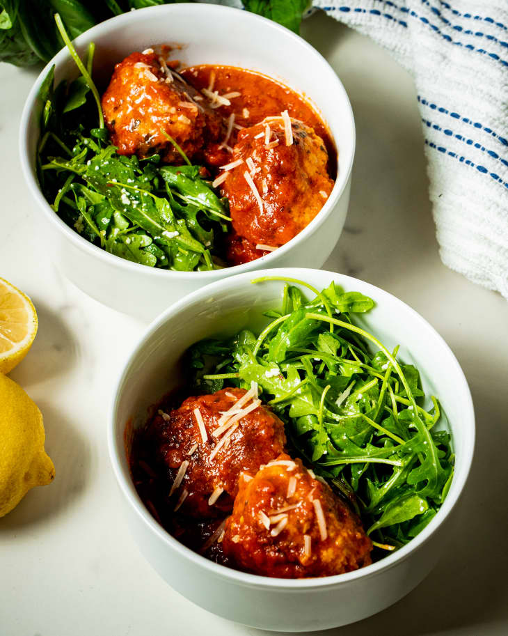 Italian meatballs in a bowl with side of arugula.