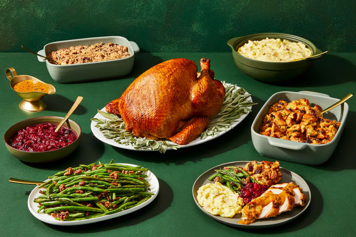 Turkey in the center of thanksgiving dinner spread.