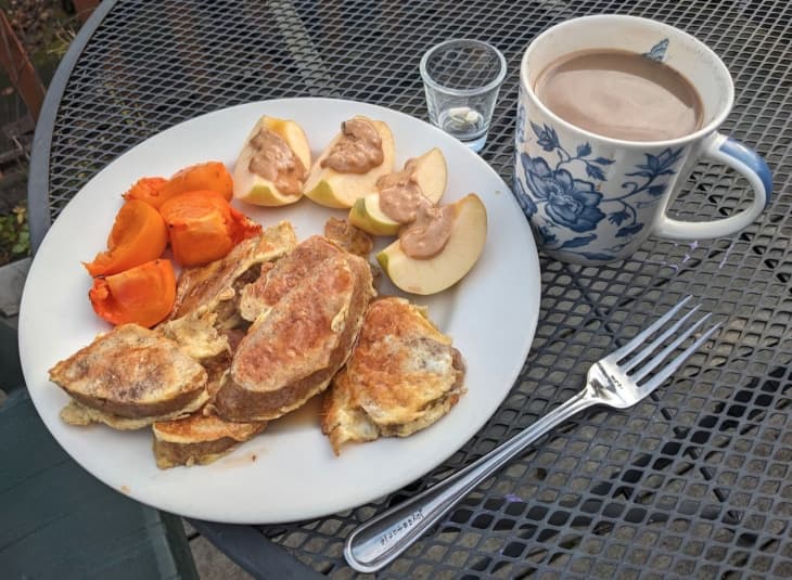 egg toast with apple slices and peanut butter, fruit and cup of coffee