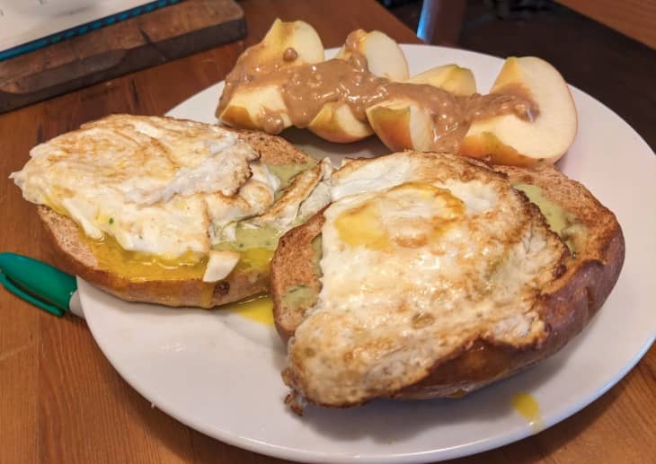 avocado and fried egg on toast with apple slices and peanut butter