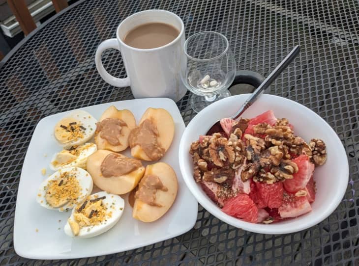 apple slices with peanut butter, deviled eggs, bowl of fruit with nuts, cup of coffee