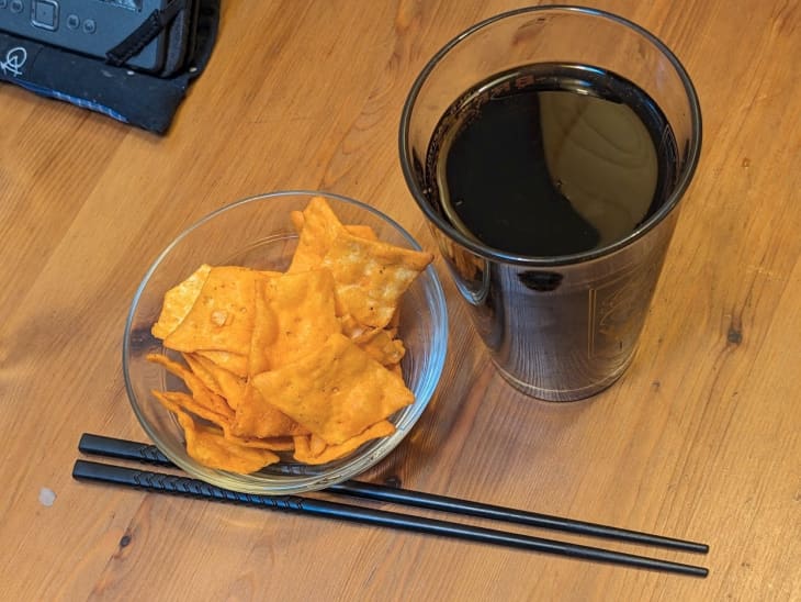 bowl of baked chips, glass of wine, chopsticks
