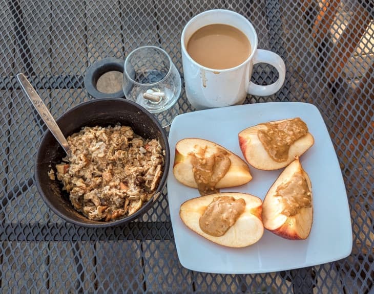 apple slices with peanut butter, bowl of granola and cup of coffee