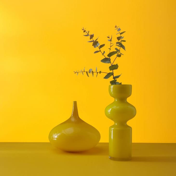 Bright yellow wall with yellow curved vases