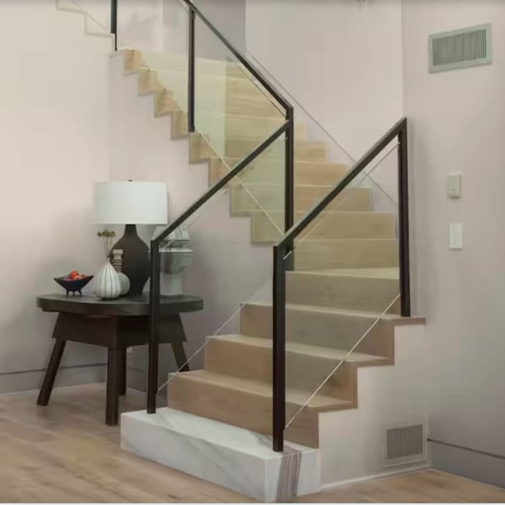 Beige walls with black hand rail staircase and marble base of stairs