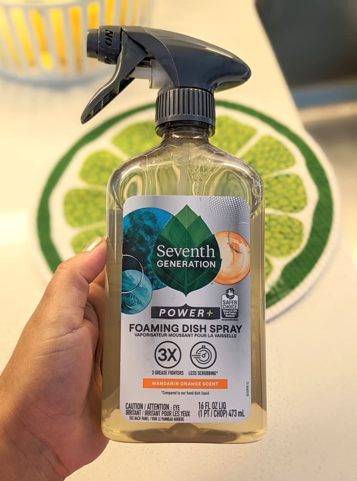 someone holding a bottle of Seventh Generation Foaming Dish Spray
