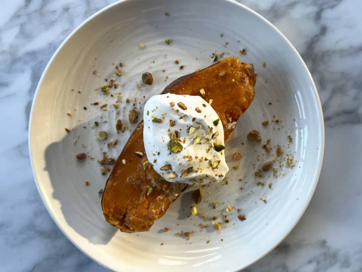 Whipped cream and pistachio on top of roasted sweet potato.