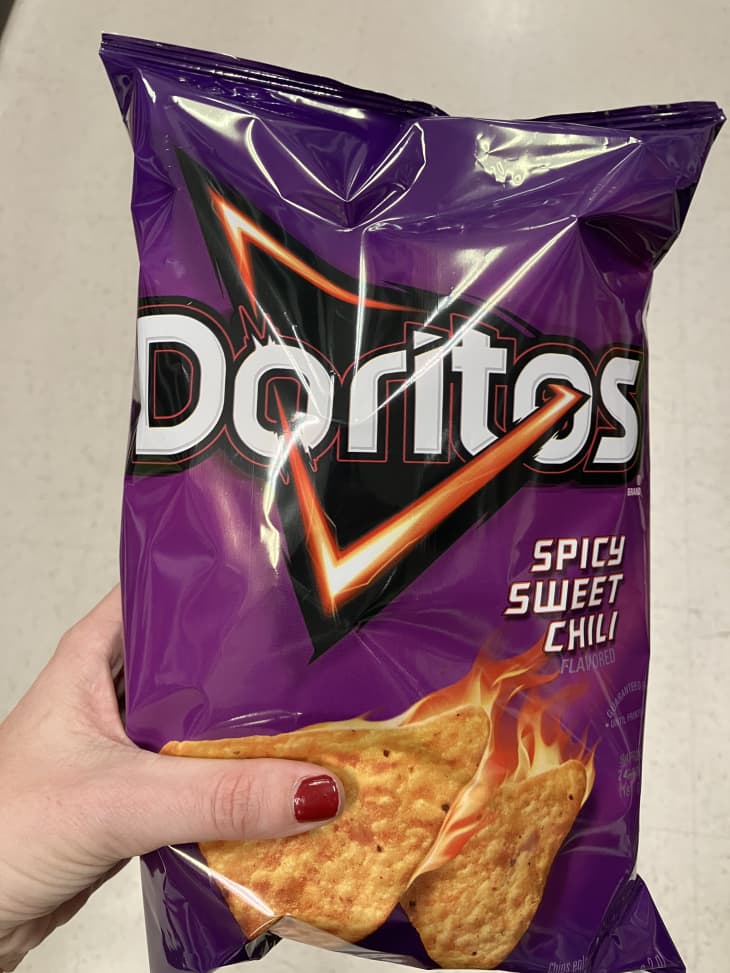 Someone holding bag of Spicy Sweet Chili Doritos