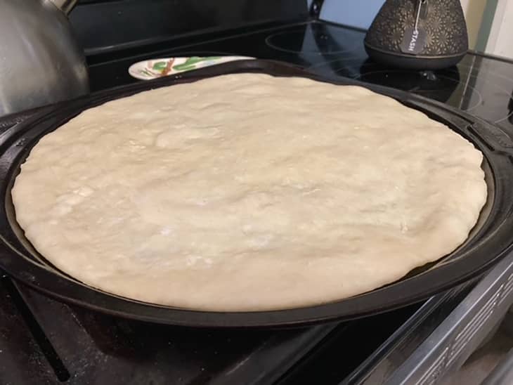 Jiffy pizza dough on baking stone.