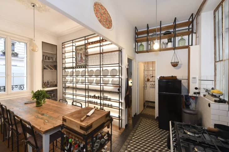 Kitchen with exposed storage and wooden table.