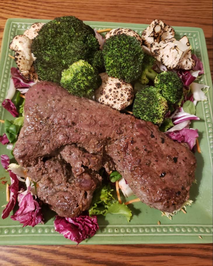 grilled steak and vegetables on green plate