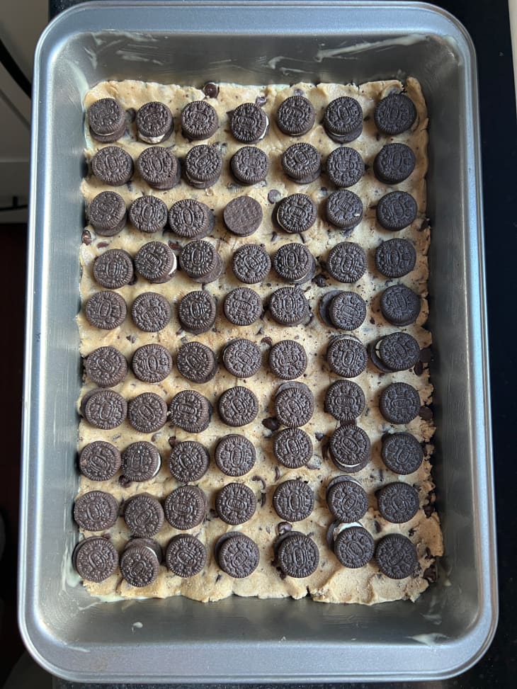 Oreos on top of cooke dough in baking pan.