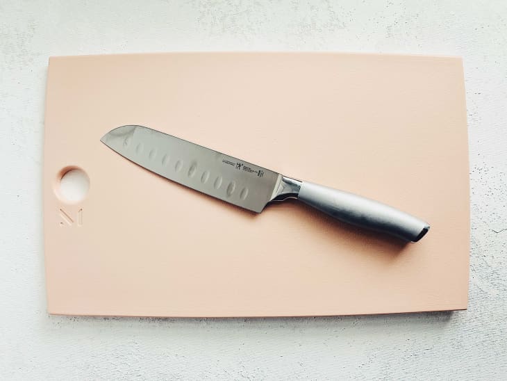 Stainless steel knife on pink cutting board