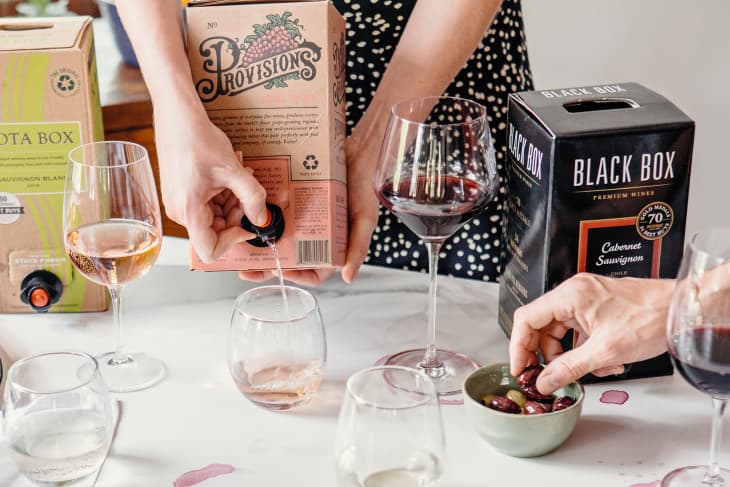 Someone pouring boxed wine into a glass