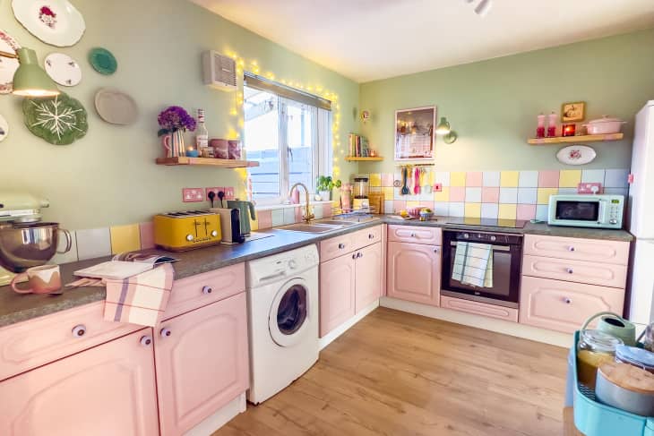 Pastel kitchen with green walls, pastel tiling, pink cabinetry, and pastel appliances and accessories.