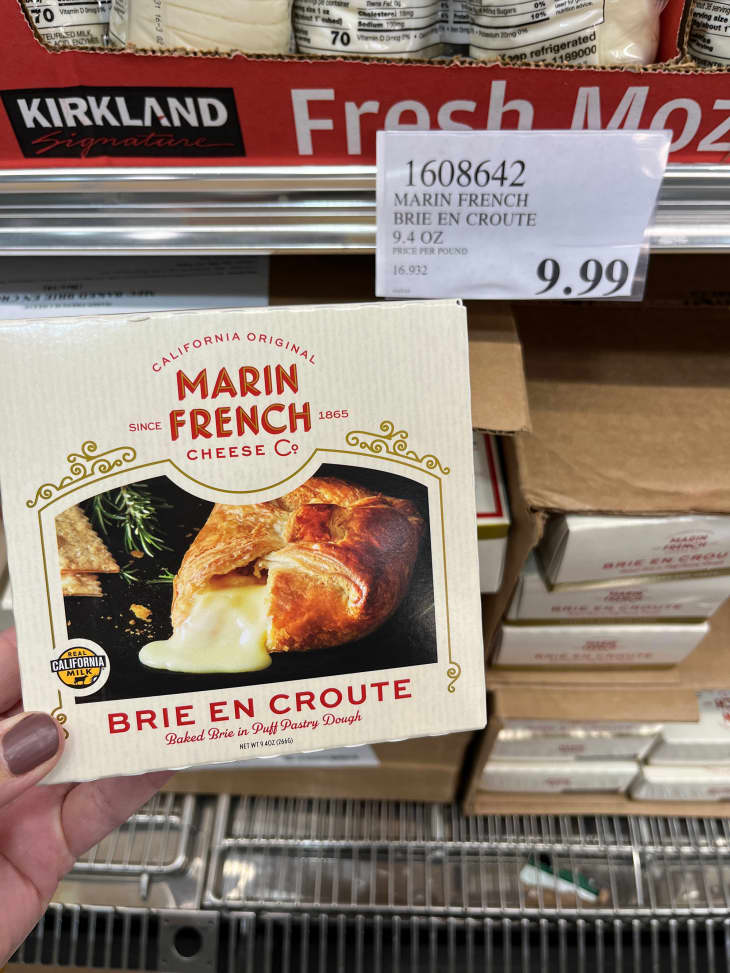 Someone holding Costco's Marin French Brie En Croute in package.