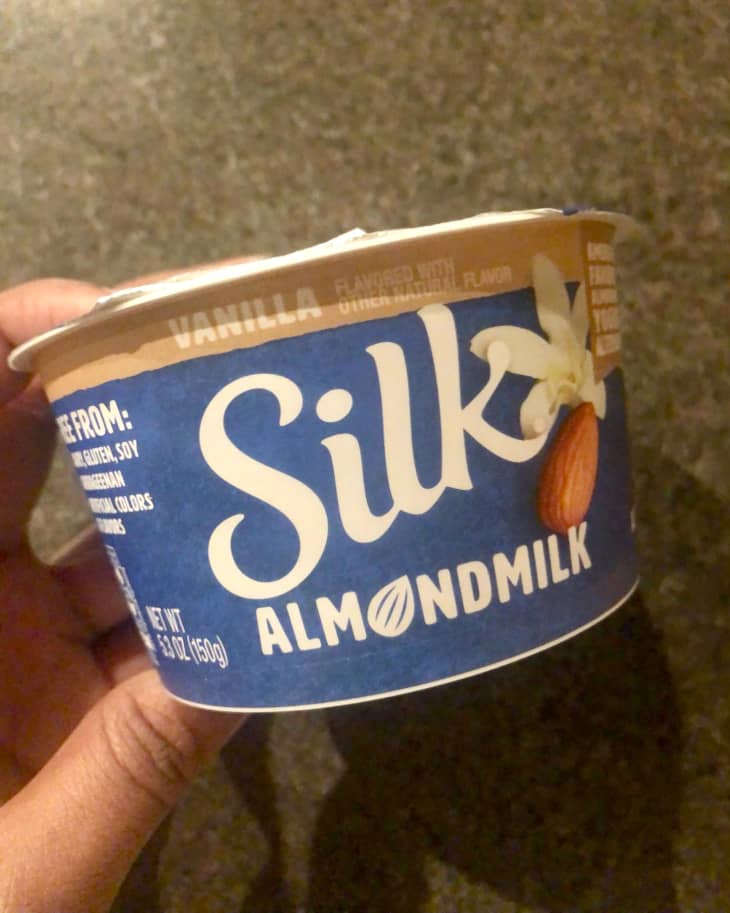 Someone holding a container of Silk Almond Milk Vanilla Non-Dairy Yogurt
