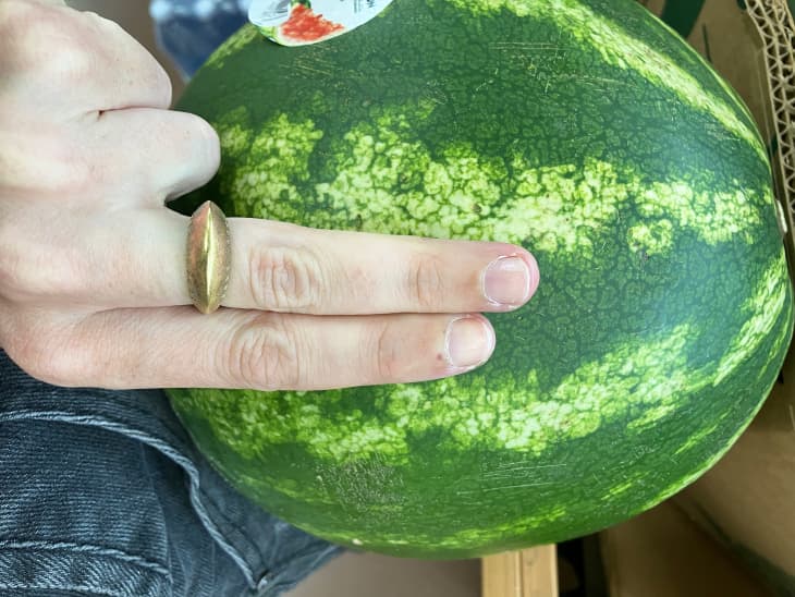 Someone with two fingers over watermelon