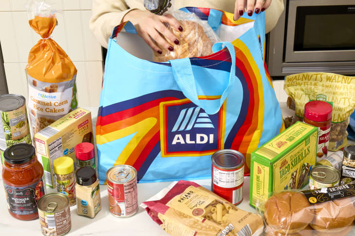 angled shot of an assortment of Aldi items in a large blue Aldi bag, and some scattered around the counter.