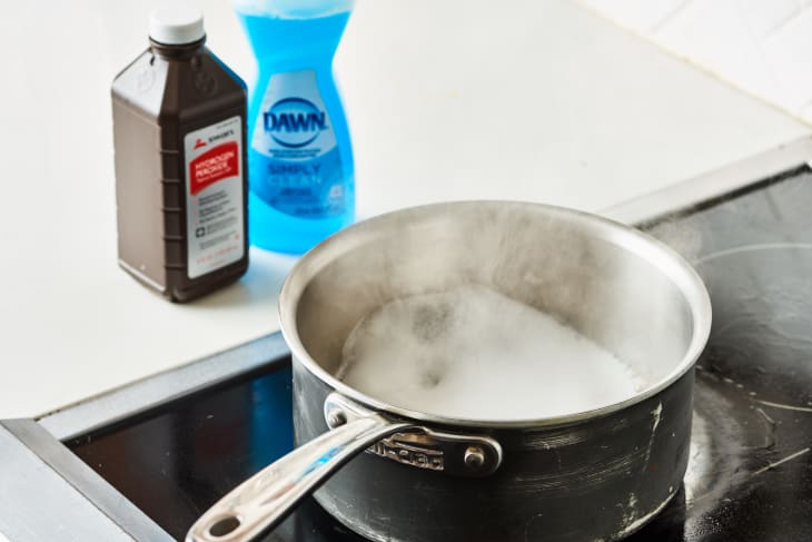 How can you use hydrogen peroxide to clean a burnt pan?