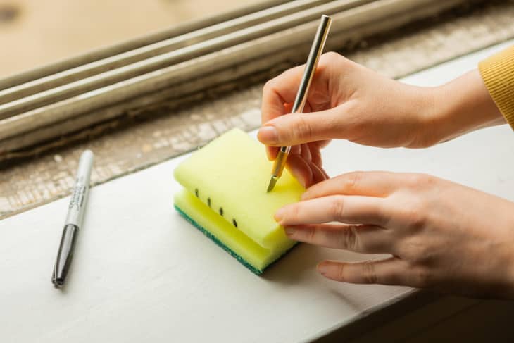 Cutting slits into a sponge where marker marks are
