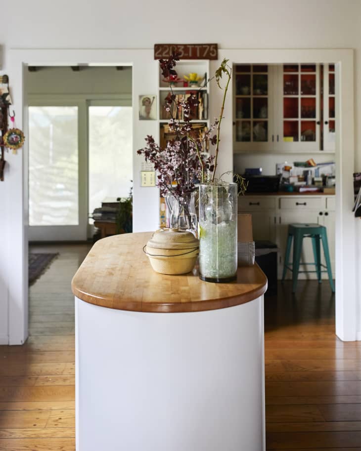 A kitchen island with plants and ceramics on top of it.