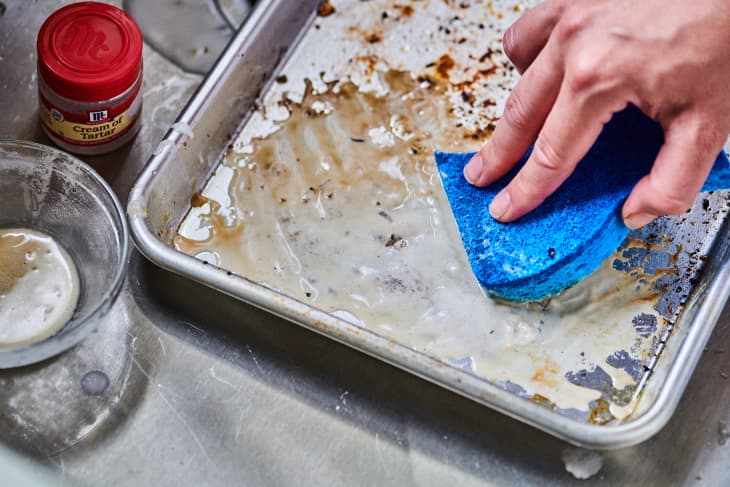applying a paste of cream of tartar and vinegar to a dirty baking sheet
