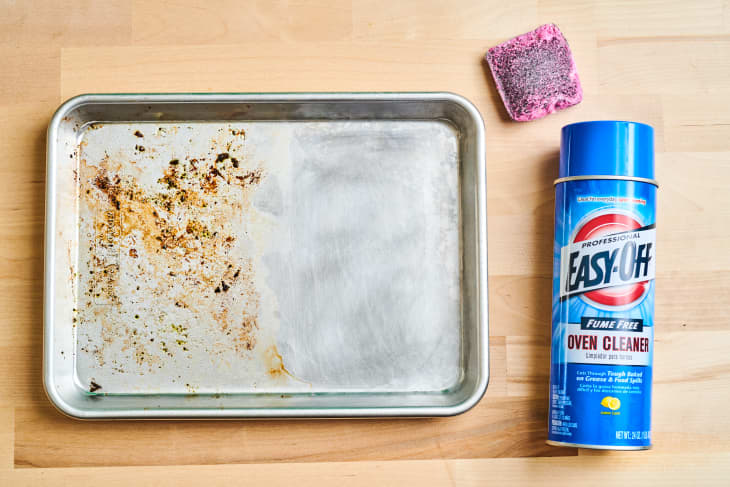 half cleaned baking sheet with easy off oven cleaner and a brillo pad