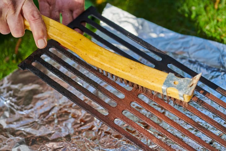 Scrubbing grill grate with a brush