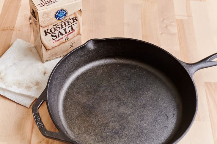 cast iron skillet after being cleaned with a box of kosher salt and dirty paper towel