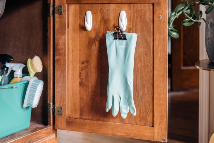 dishgloves hanging on a cabinet door on a command hook