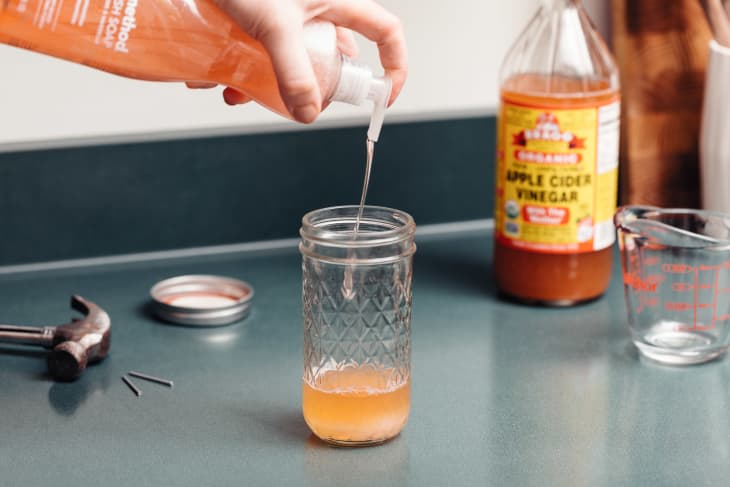 squirting some dish soap into a mason jar filled with some apple cider vinegar to make a DIY fruit fly trap