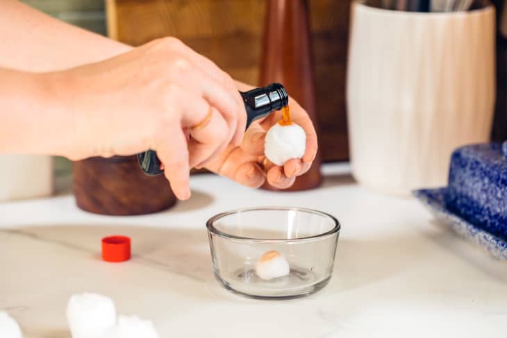 Moistening a cotton bowl with vanilla extract, to put into a bowl