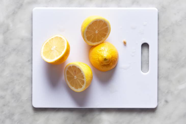 Lemon halves on a plastic cutting board.