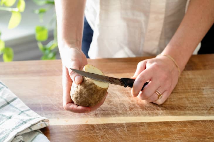 Rusty knife cutting potato