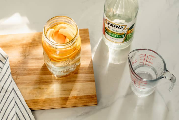 Mason jar filled with orange peels and white vinegar.