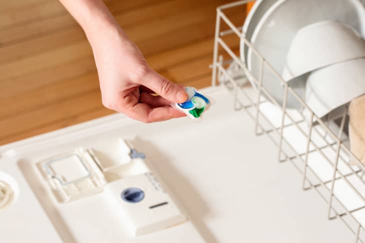 Dishwashing pod being placed in dishwasher.