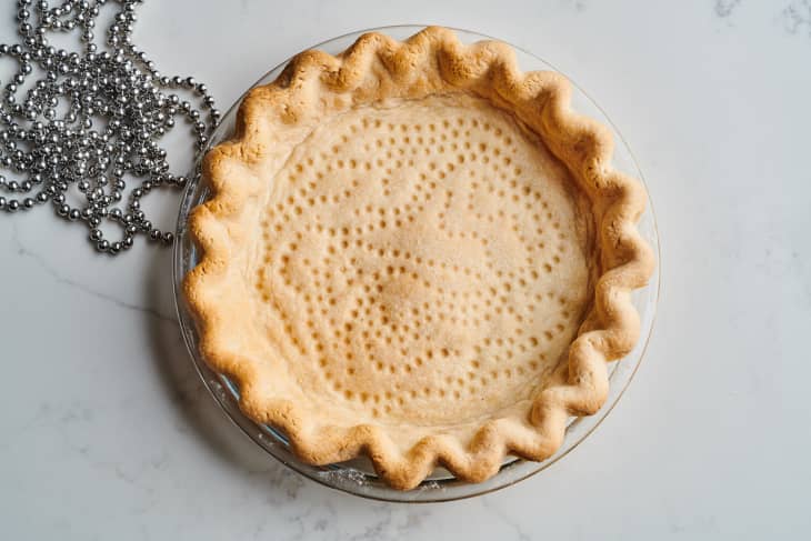 pie crust in tin sits next to metal chain weight