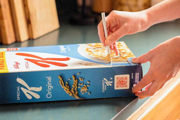 Someone using exacto knife to cut bottom of cereal box.