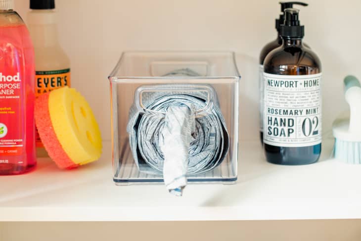 Roll of trash bags in clear storage container.