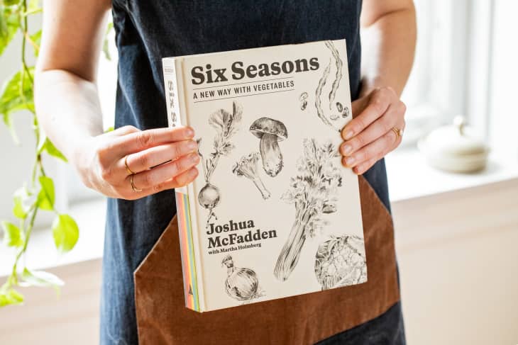 Someone holding Six Seasons by Joshua McFadden.