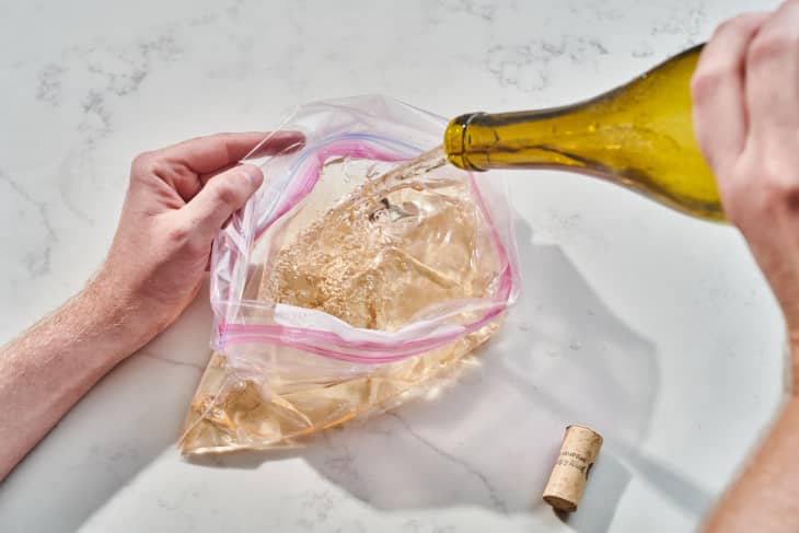 someone pouring wine in a bag
