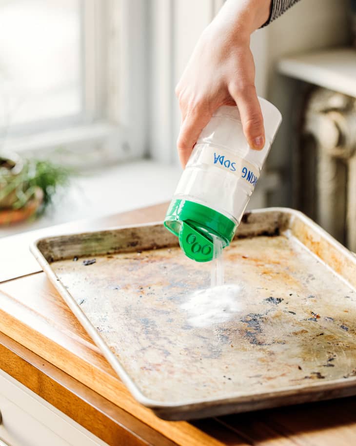Pouring parmesan container onto baking sheet