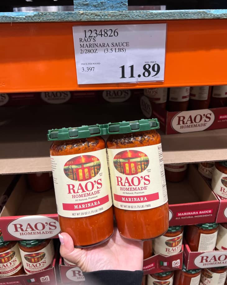 Someone holding up a package of Rao’s Homemade Marinara Sauce in Costco store