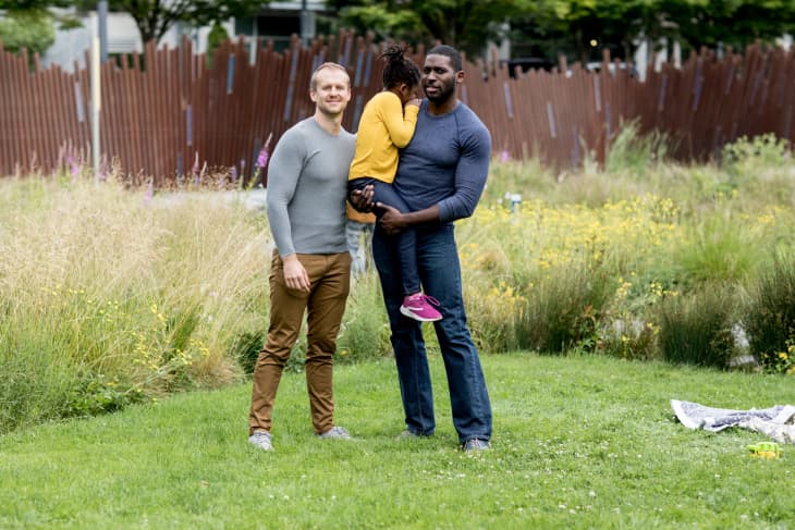 Portrait of Antwon, Nate, and their daughter in the park